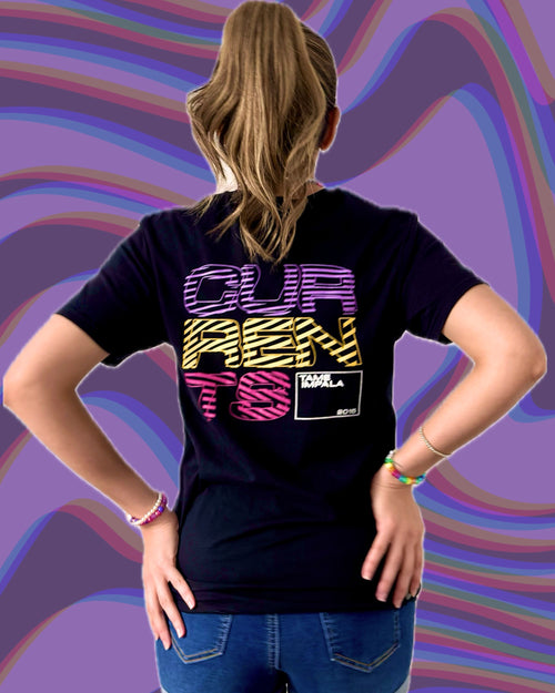 A woman shown from the back wearing a black graphic t-shirt with a colorful retro-style text design reading 'CURRENTS' in purple, yellow, and pink.