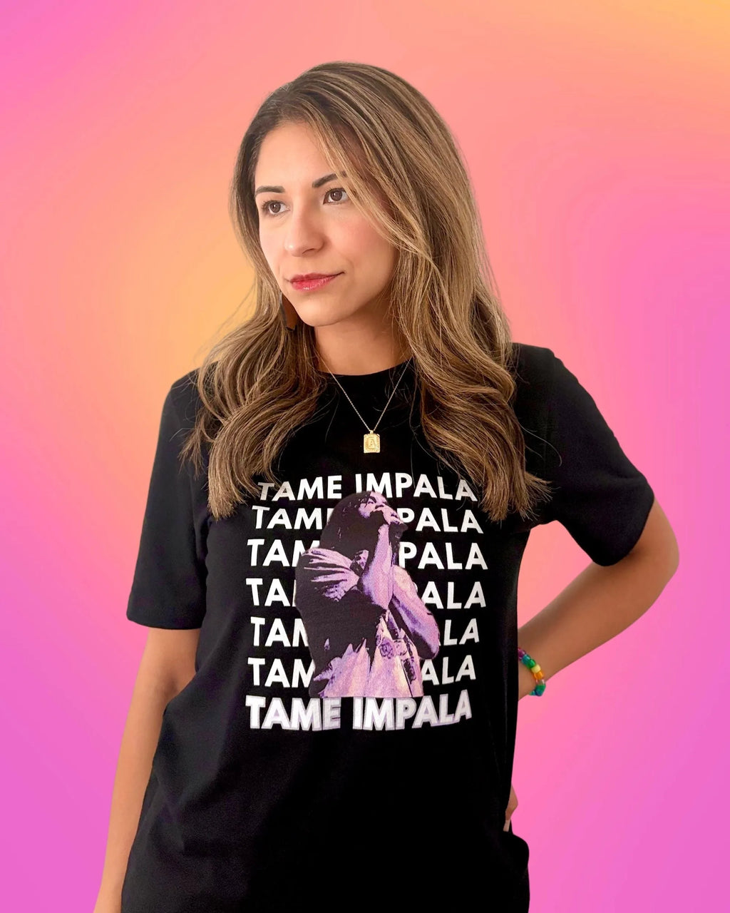Model is wearing a black Tame Impala t-shirt with Tame Impala in repeating text and Kevin Parker in a purple filter, front of shirt