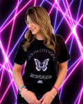 A woman wearing a black graphic t-shirt with a light lavender butterfly design and the text 'YES I'M CHANGING' and lyrics from the Tame Impala song, set against a vibrant purple and pink neon background.